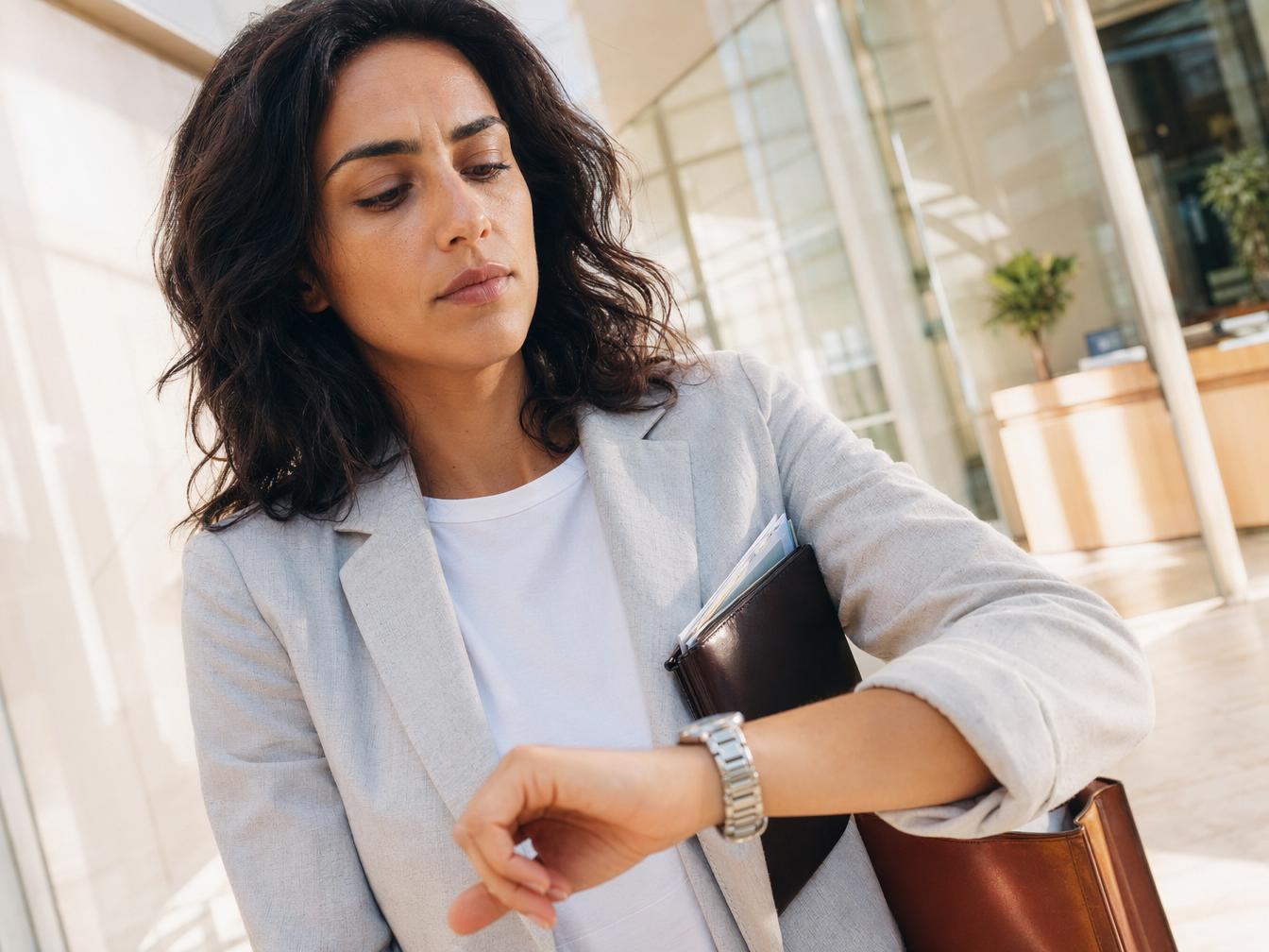 Femme d'affaires regardant sa montre au bureau