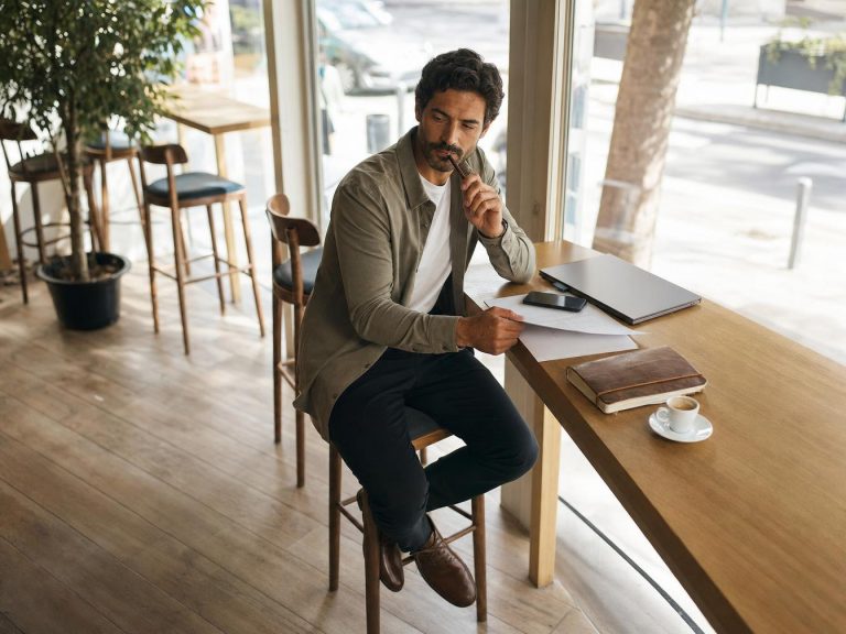 Homme réfléchissant à une table de café
